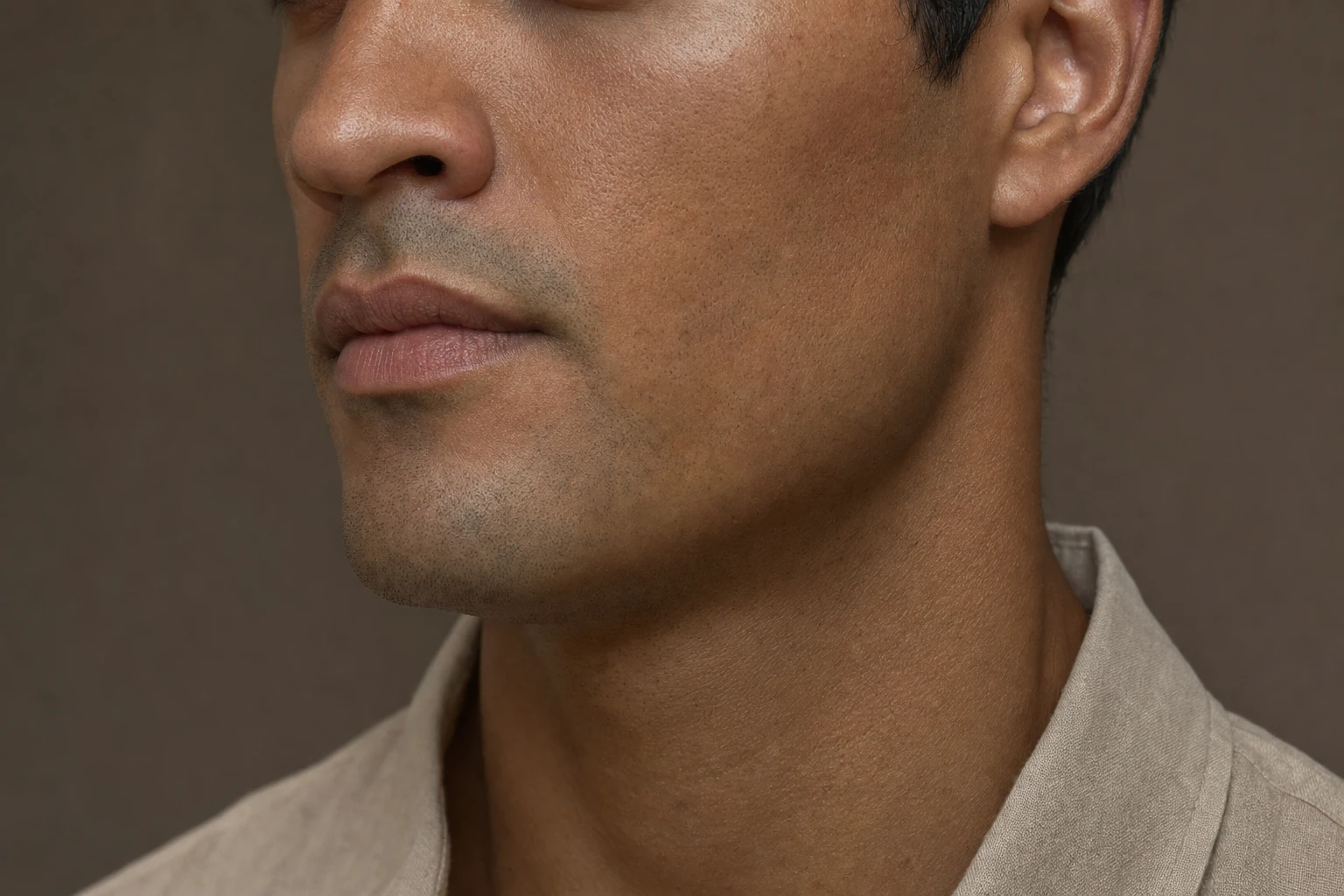 Lower face of a man at a three-quarter angle, showing the natural jawline.